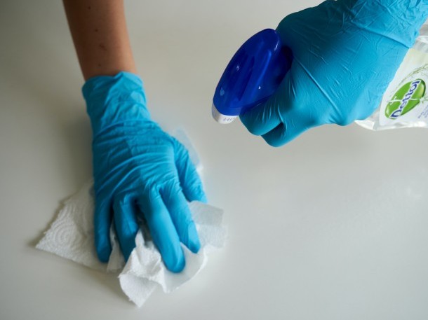 Mitarbeiter mit Handschuhen und Desinfektionsmittel 