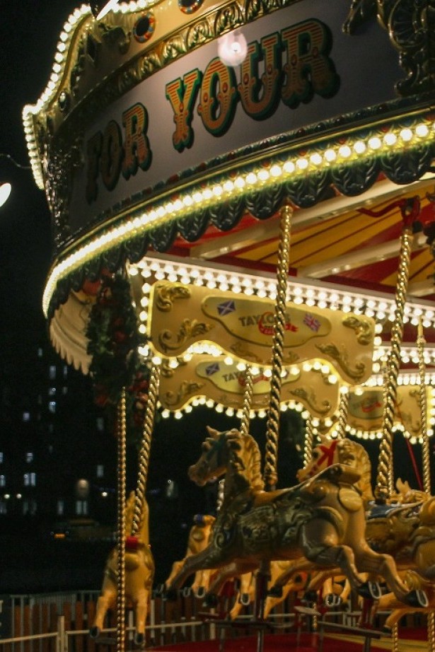 Illuminated nostalgic carousel with horses and carriages 