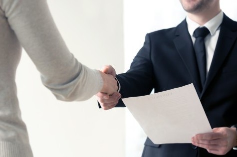 Handshake at a job interview with documents 