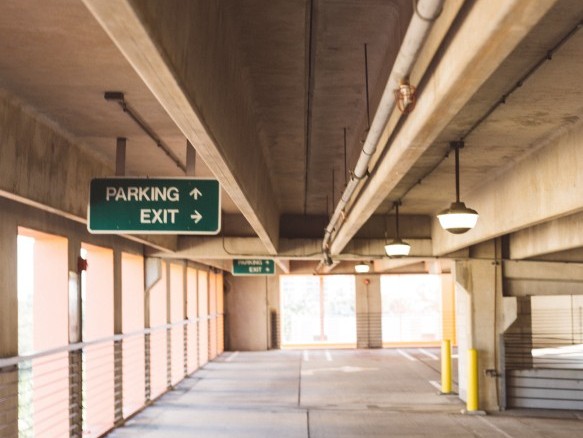 Leere Parkgarage mit Wegweisern.