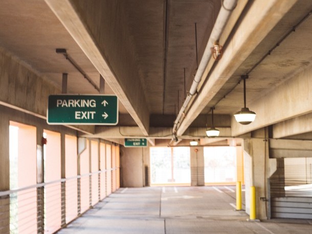 Leere Parkgarage mit Wegweisern.