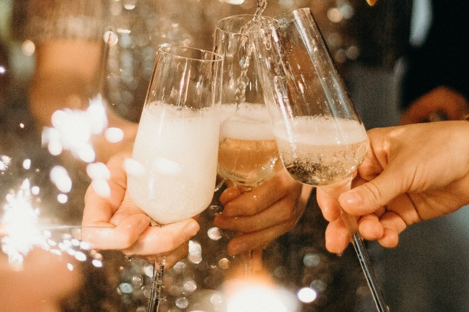 Silvesterfeier, bei der drei Sektgläser gefüllt werden. 