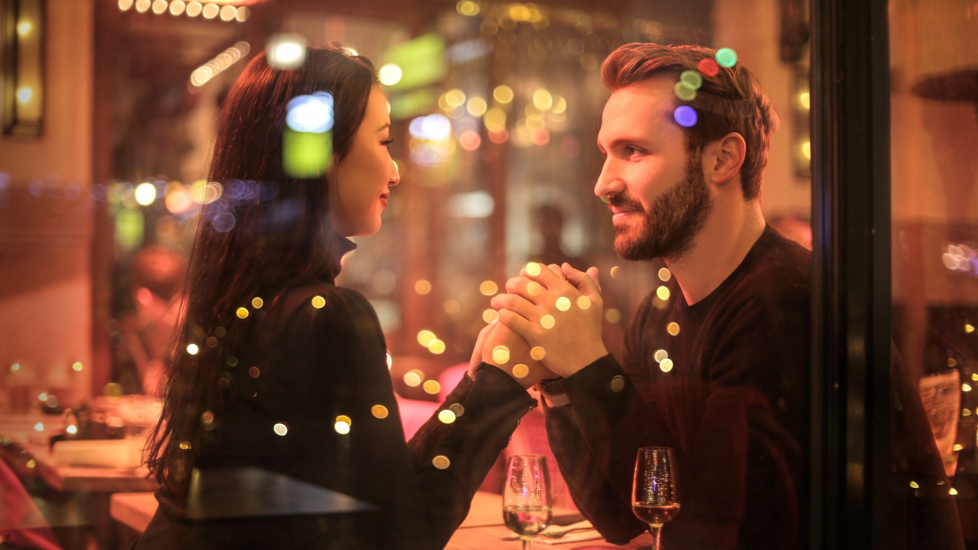 A man and a woman are seated at a romantic candlelight dinner.