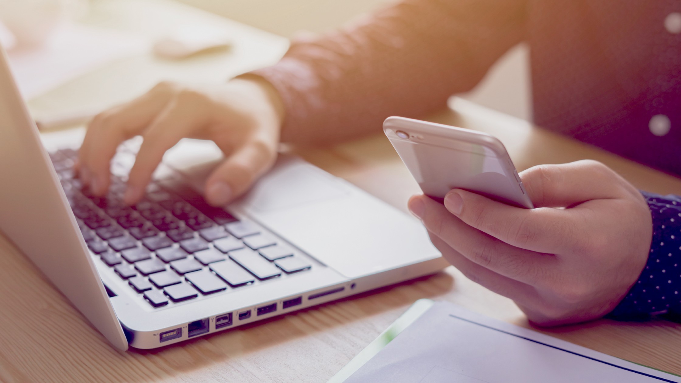 Working multitasking with a laptop and cell phone.