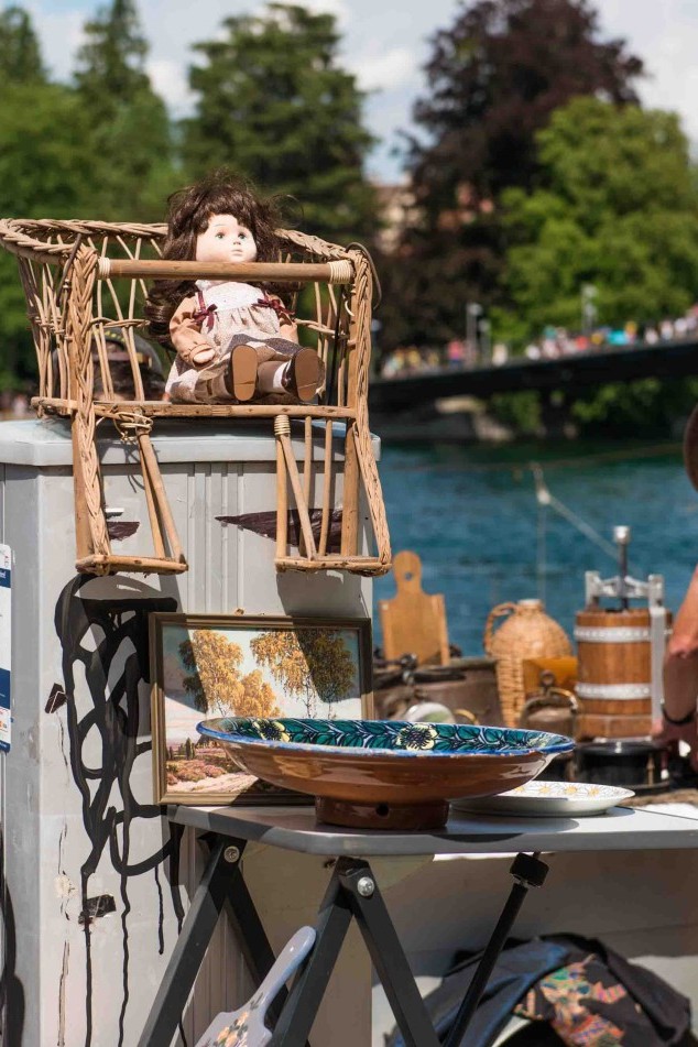 Zwei Verkäufer präsentieren ihre Stände auf dem Flohmarkt in Konstanz, umgeben von Stöberfreudigen und bunten Waren