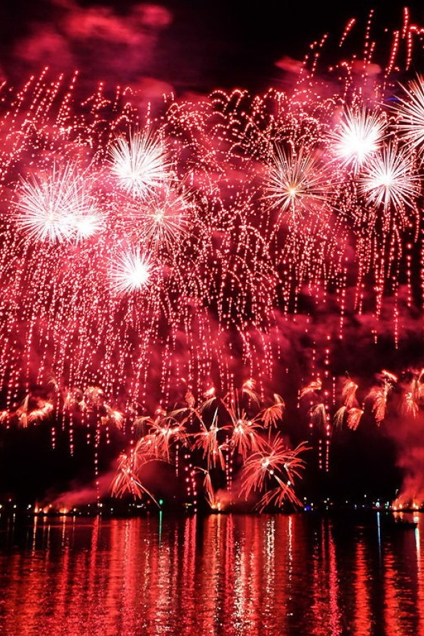 Rotes Feuerwerk erleuchtet den Nachthimmel über dem Bodensee beim Konstanzer Seenachtfest