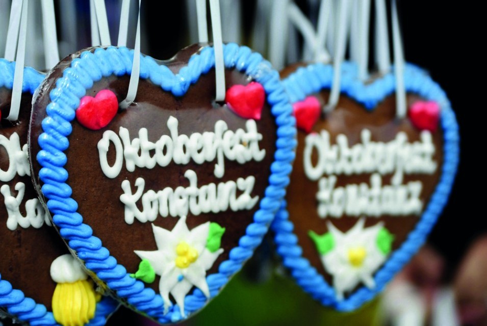 Bunte Lebkuchenherzen mit Aufschriften hängen als Dekoration auf dem Oktoberfest