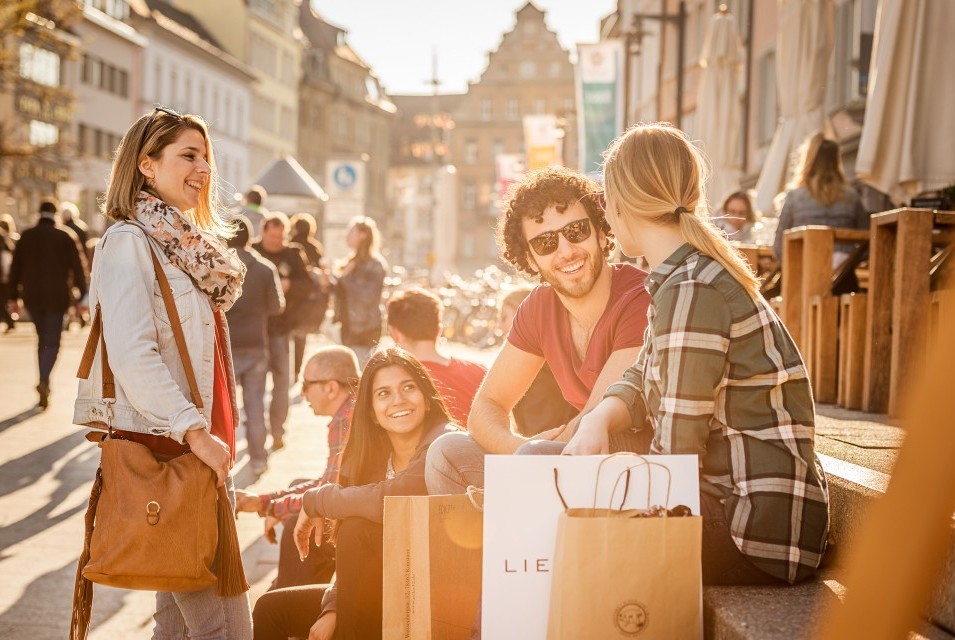 People sitting in downtown Konstanz with shopping bags