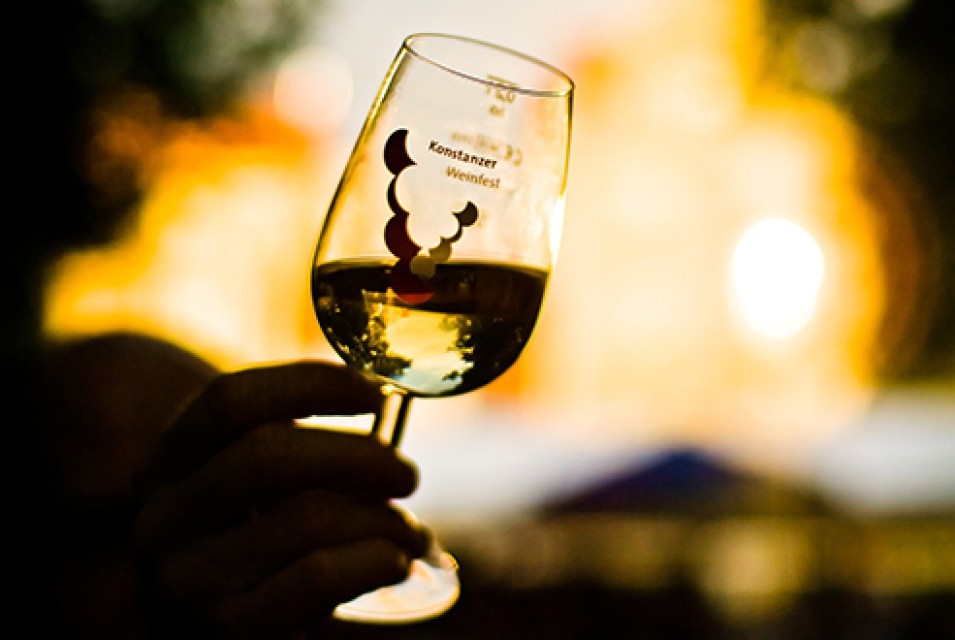 Nahaufnahme eines Glases mit Weisswein vor unscharfem Hintergrund