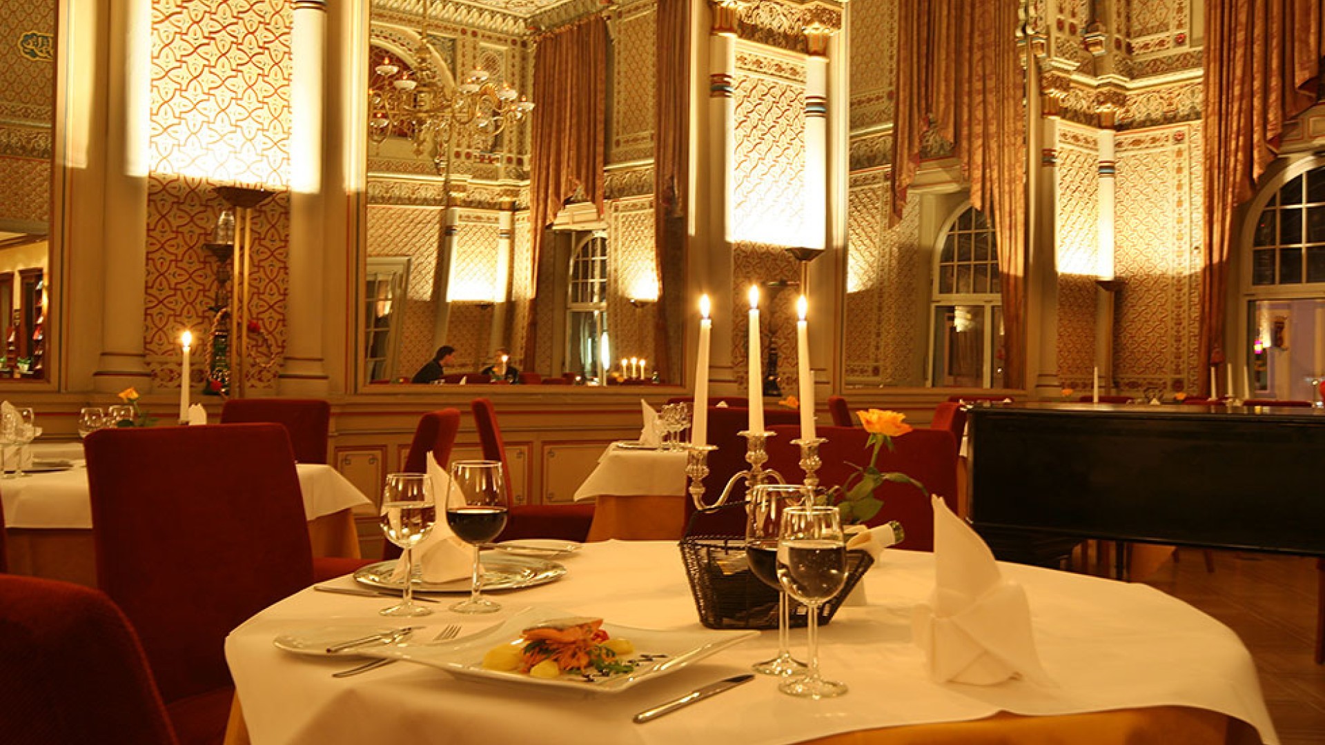 Festively decorated table by candlelight with fantastic food and wine.