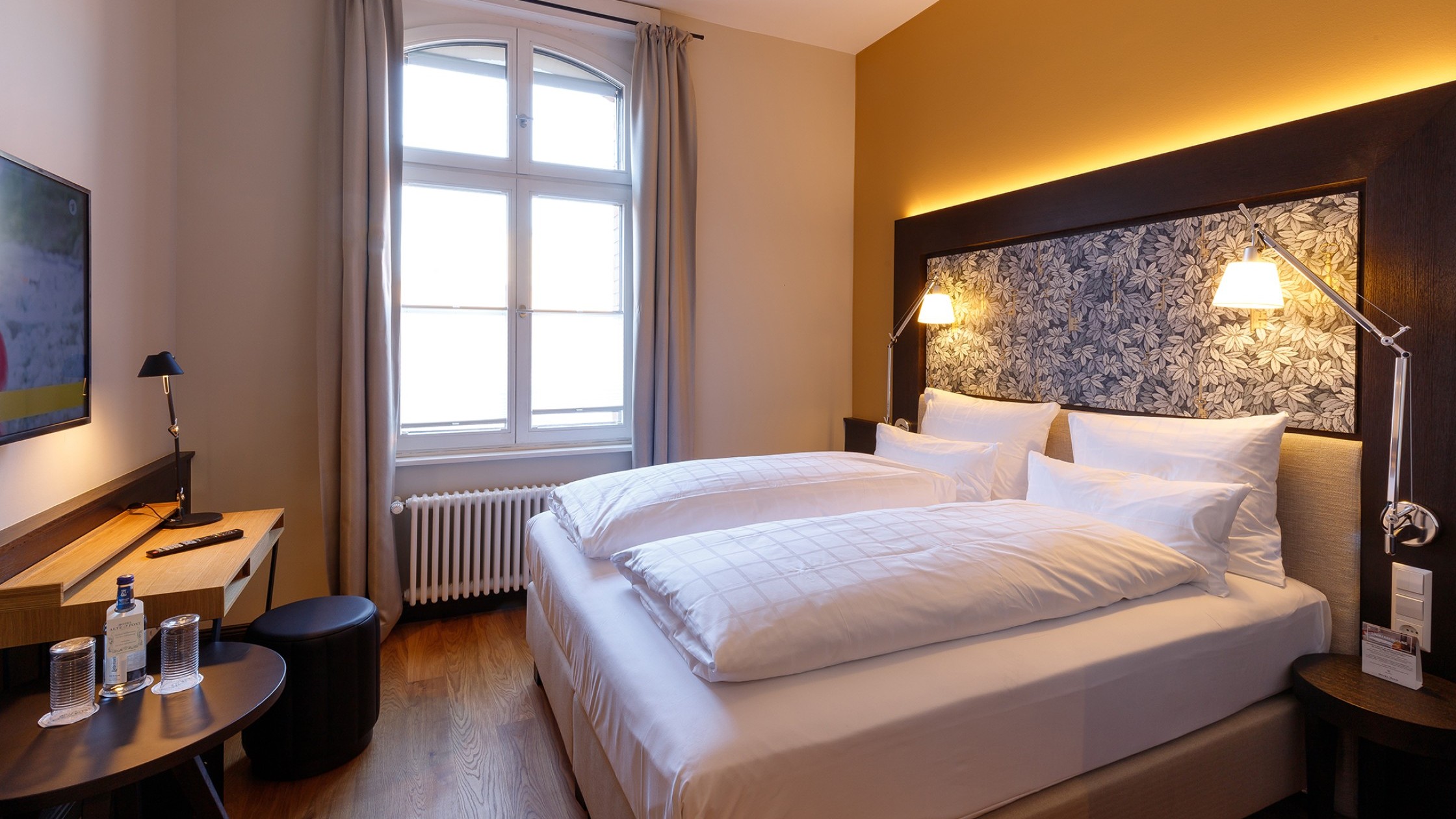 Ein stilvoll eingerichtetes Doppelzimmer im Hotel Alte Post mit modernen Textilien, Holzmöbeln und harmonischer Beleuchtung.