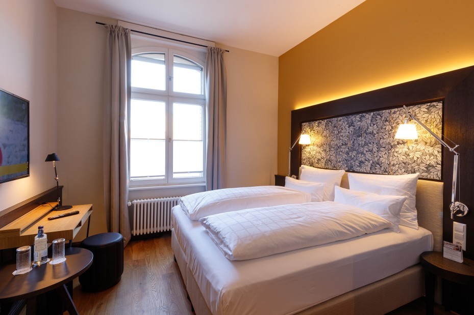 Ein stilvoll eingerichtetes Doppelzimmer im Hotel Alte Post mit modernen Textilien, Holzmöbeln und harmonischer Beleuchtung.