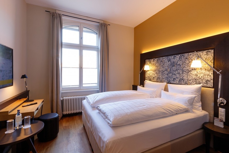 Ein stilvoll eingerichtetes Doppelzimmer im Hotel Alte Post mit modernen Textilien, Holzmöbeln und harmonischer Beleuchtung.