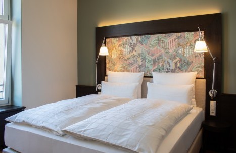 Elegant double bed with premium linens in a stylishly decorated room at Hotel Alte Post