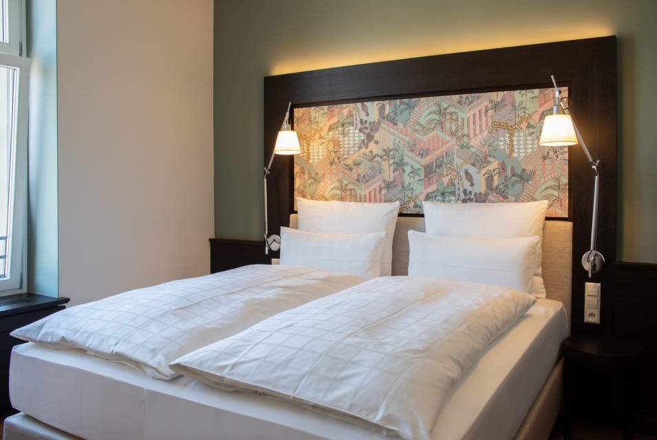 Elegant double bed with premium linens in a stylishly decorated room at Hotel Alte Post