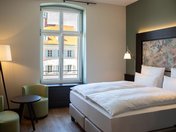 Modern eingerichtetes Hotelzimmer mit Doppelbett, Marmorbadezimmer und gemütlichem Sitzbereich im Hotel Alte Post in Konstanz